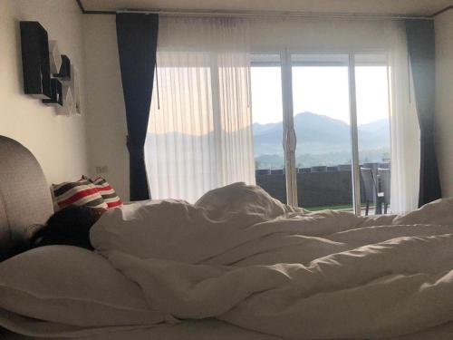 a person laying in a bed in front of a window at C View Home in Nan