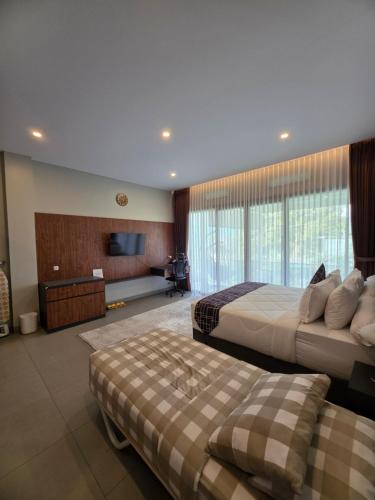 a hotel room with two beds and a television at Royal Hill Villa Cisarua Puncak in Puncak