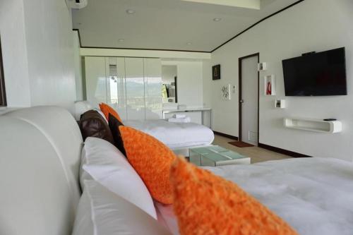 a hotel room with two beds with orange pillows at C View Home in Nan