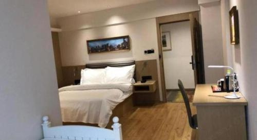 a hotel room with a bed and a desk at Metropolo Hotel Qingdao Wusi Square Xiaomaidao in Qingdao