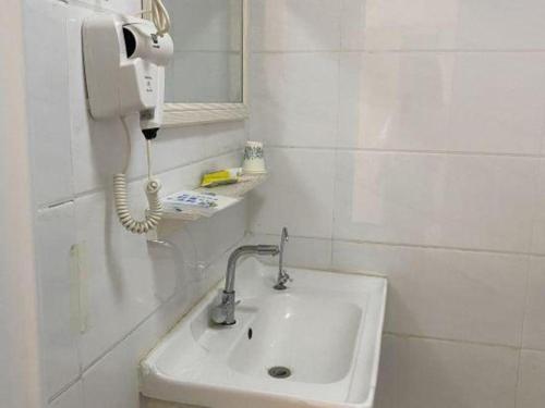 a bathroom with a sink and a phone on the wall at 7Days Inn Tianjin Airport NO.1 Bridge Branch in Tianjin