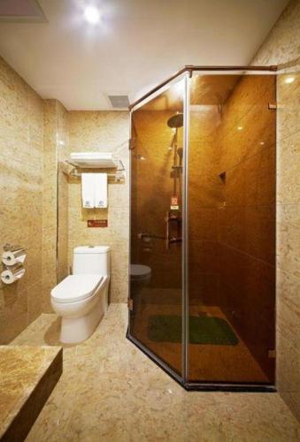 a bathroom with a toilet and a glass shower at Li An Hotel Shantou Xiashan Central Bus Station Branch in Shantou