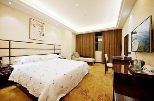 a hotel room with a bed and a desk at Li An Hotel Shantou Xiashan Central Bus Station Branch in Shantou