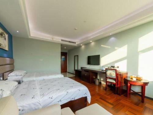 a large bedroom with two beds and a desk at Li An Hotel Shantou Xiashan Central Bus Station Branch in Shantou