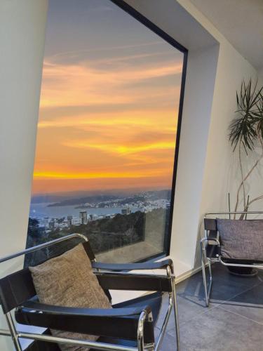 a room with a large window with a sunset at Luxury Wellington Accomodation in Wellington