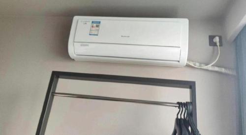 a air conditioner on a wall next to a mirror at Jinjiang Inn Style Shijiazhuang Zhongshan Xi Road Yuxi Park in Shijiazhuang