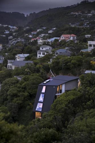a house with a black roof on a hill at Luxury Wellington Accomodation in Wellington
