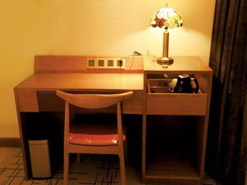 a desk with a chair next to a desk with a lamp at James Joyce Coffetel·Anyang Text Museum in Anyang