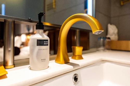 a bottle of soap sitting on a sink next to a faucet at James Joyce Coffetel·Anyang Text Museum in Anyang