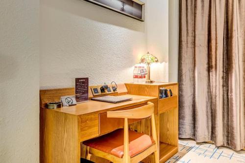 a wooden desk with a chair and a keyboard at James Joyce Coffetel·Anyang Text Museum in Anyang