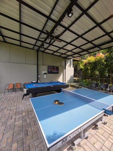 a patio with two ping pong tables under awning at Royal Hill Villa Cisarua Puncak in Puncak