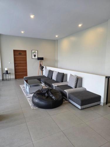 a living room with two couches and a black tire at Royal Hill Villa Cisarua Puncak in Puncak