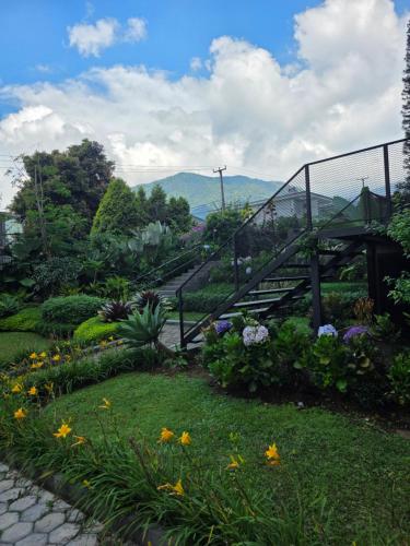 a view of a garden with a bridge and flowers at Royal Hill Villa Cisarua Puncak in Puncak