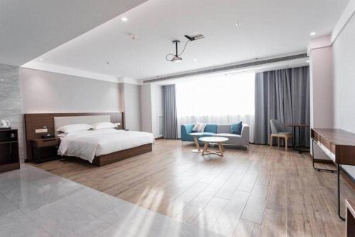 une chambre d'hôtel avec un lit, une table et des chaises dans l'établissement Borrman Hotel East Huai'an Railway Station Zhou 'Enlai Memorial, à Hexia
