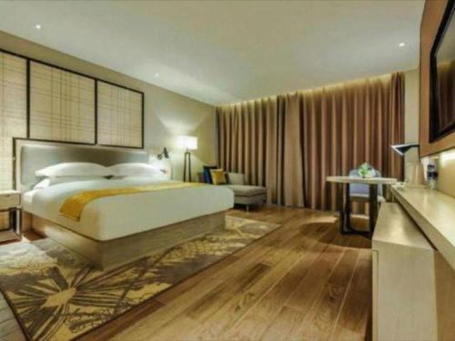 a bedroom with a large bed and a couch at Echarm Hotel Anshun High-speed Railway Station Jichang Road in Anshun