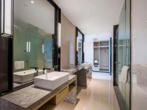 a large bathroom with a sink and a mirror at Echarm Hotel Yiyang Wanda Plaza in Yiyang