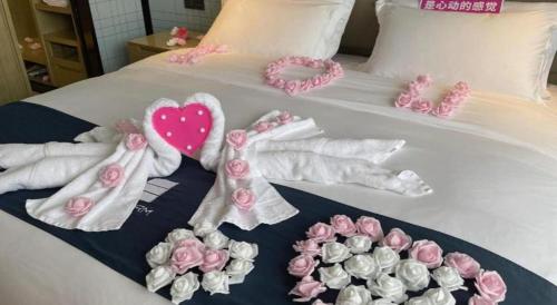 a group of towels and flowers on a bed at Echarm Hotel Nanning Chaoyang Square River View in Nanning