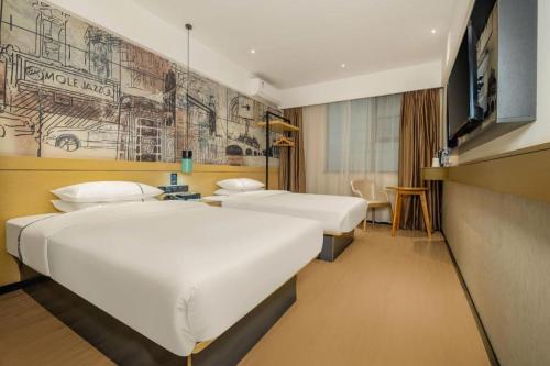 a hotel room with two beds and a tv at City Comfort Inn Beiliu Yongfeng Plaza Chengnan Bus Station in Yulin