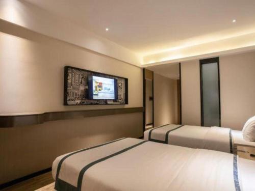 a hotel room with two beds and a flat screen tv at City Comfort Inn Beiliu Yongfeng Plaza Chengnan Bus Station in Yulin