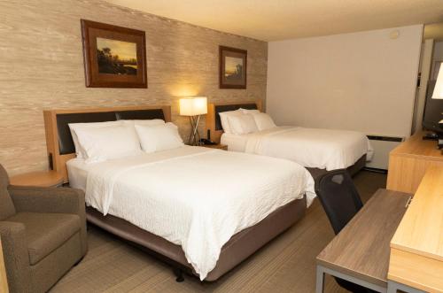 a hotel room with two beds and a chair at Holiday Inn Spearfish-Convention Center by IHG in Spearfish