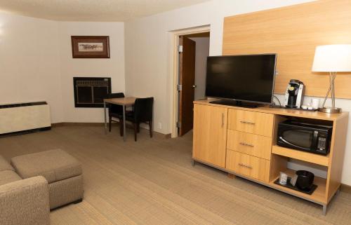a living room with a flat screen tv and a couch at Holiday Inn Spearfish-Convention Center by IHG in Spearfish