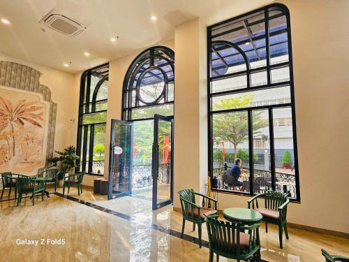 a restaurant with tables and chairs and large windows at Swan Boutique Hotel in Ho Chi Minh City