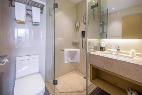a bathroom with a shower and a toilet and a sink at City Comfort Inn Liuzhou Wuling Liutai Road in Liuzhou