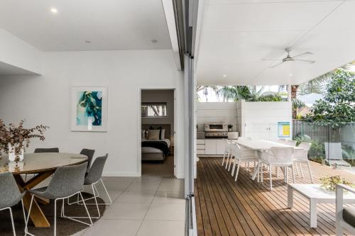 a kitchen and dining room with a table and chairs at Fat Frog Beach Houses in Byron Bay
