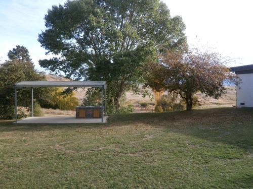 a picnic shelter in a yard with a tree at Siesta Villa in Jindabyne