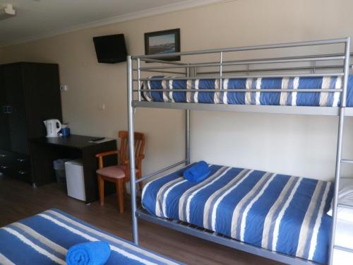 a bedroom with two bunk beds and a desk at Siesta Villa in Jindabyne