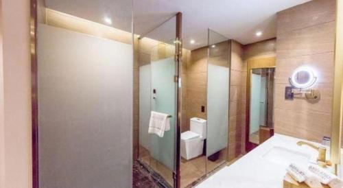 a bathroom with a large mirror and a sink at James Joyce Coffetel Changchun People's Square in Changchun