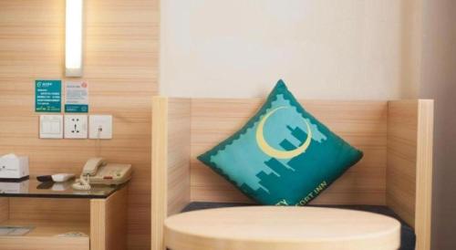 a green pillow sitting on the back of a room at City Comfort Inn Yichang Dongshan Three Gorges University Shuiyuecheng in Yichang