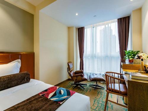a hotel room with a bed and a desk and a window at James Joyce Coffetel· Xianyang Renmin Road Central Square Store in Xianyang