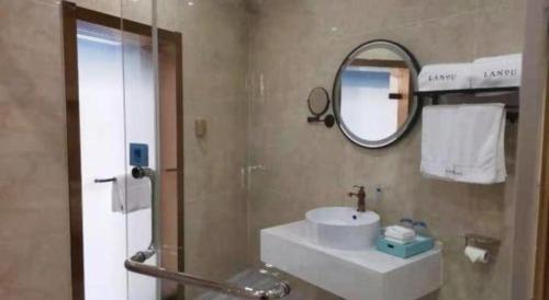 a bathroom with a sink and a mirror at LANO Hotel Shandong Qingdao Jimo District Baolong Square in Qingdao
