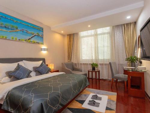 a bedroom with a bed and a living room at Chonpines Hotel Jining Quanmin Fitness Plaza in Jining