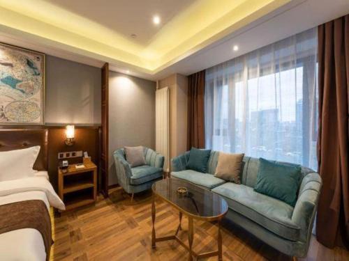 a hotel room with a couch and a bed at James Joyce Coffetel Harbin West High-speed Railway Station Wanda Plaza in Harbin