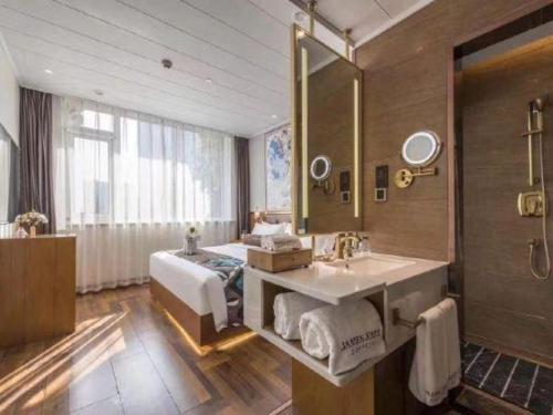 a bathroom with a sink and a mirror at James Joyce Coffetel Harbin West High-speed Railway Station Wanda Plaza in Harbin