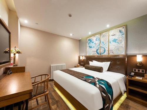 a hotel room with a large bed and a desk and a desk at James Joyce Coffetel Harbin West High-speed Railway Station Wanda Plaza in Harbin