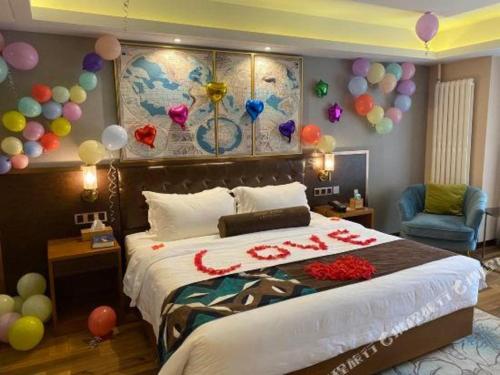 a bedroom with a large bed with balloons on the wall at James Joyce Coffetel Harbin West High-speed Railway Station Wanda Plaza in Harbin