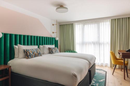 a large bed in a room with a green wall at Hotel Indigo London Clerkenwell by IHG in London