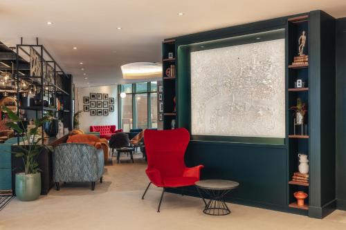 a lobby with a red chair and a table at Hotel Indigo London Clerkenwell by IHG in London