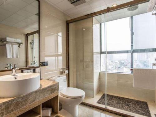 un bagno con lavandino, WC e doccia di Borrman Hotel Beihai Avenue High-speed Railway Station a Beihai