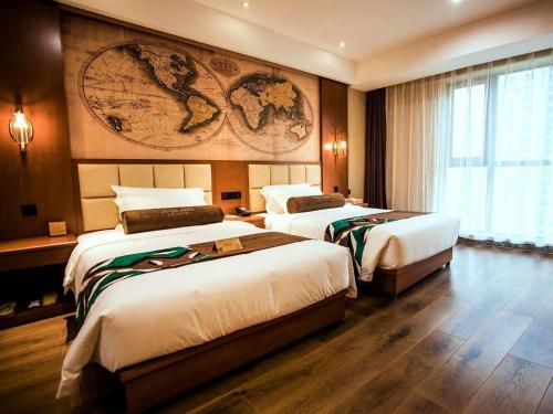 two beds in a hotel room with a map on the wall at James Joyce Coffetel Xinyang Municipal Government Railway Station in Xinyang