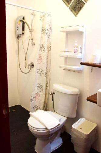 a bathroom with a toilet and a shower at Barefeet Naturist Resort in Bang Khen