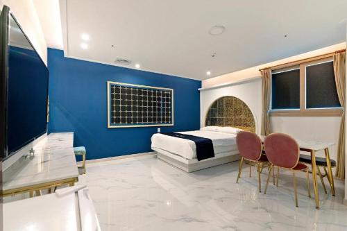 a bedroom with a bed and a table and chairs at The Bay hotel & pool villa in Suncheon