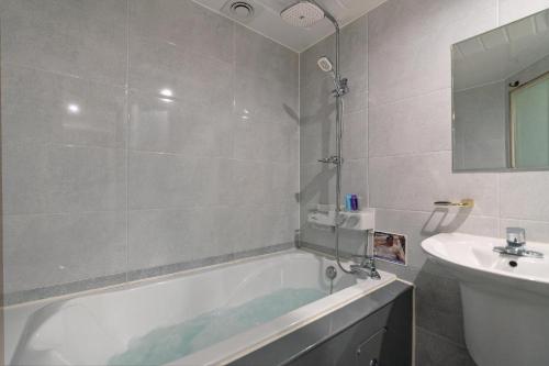 a bathroom with a bath tub and a sink at The Bay hotel & pool villa in Suncheon