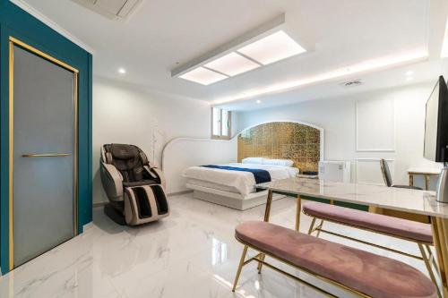 a bedroom with a bed and a table and a chair at The Bay hotel & pool villa in Suncheon