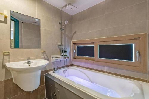 a bathroom with a sink and a bath tub and a sink at The Bay hotel & pool villa in Suncheon