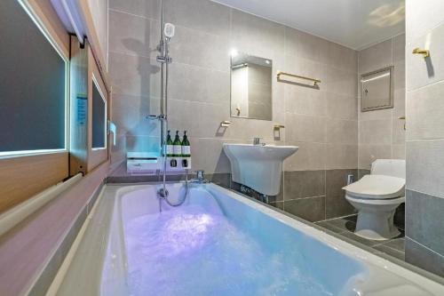a bathroom with a tub with a sink and a toilet at The Bay hotel & pool villa in Suncheon