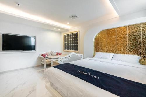 a bedroom with a bed and a flat screen tv at The Bay hotel & pool villa in Suncheon